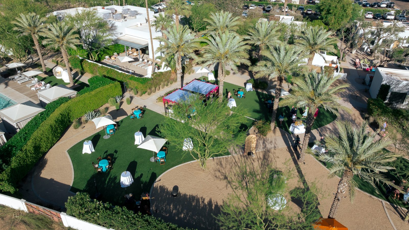 Aerial view of a wedding cocktail hour at Andaz Scottsdale, with pool cabanas, palm trees and a canopied bar