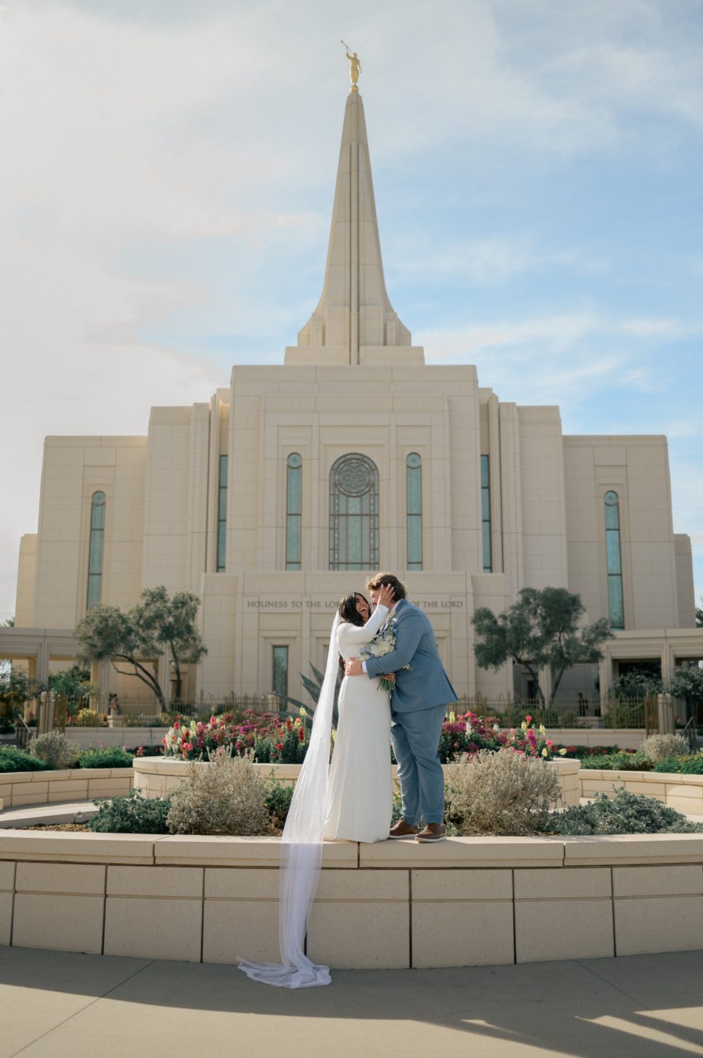 Talia and Enoch embrace in front of the Gilbert Arizona Temple after their sealing