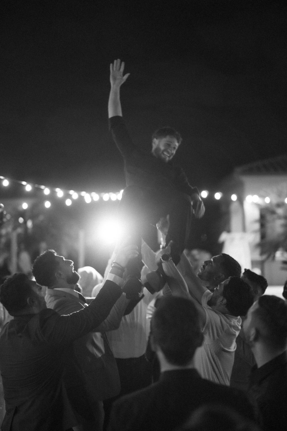 The men of the family lift Khalid into the air during the dancing at his Palestinian engagement party